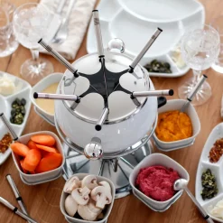 Fondueset 1 x Fonduetopf, 1 x Spritzschutz, 1 x Rechaud mit Drehkarusell, 1 x Brenner, 6 x Fonduegabeln, 6 x Fonduelöffel, 6 x Schälchen, 6 x Fondueteller